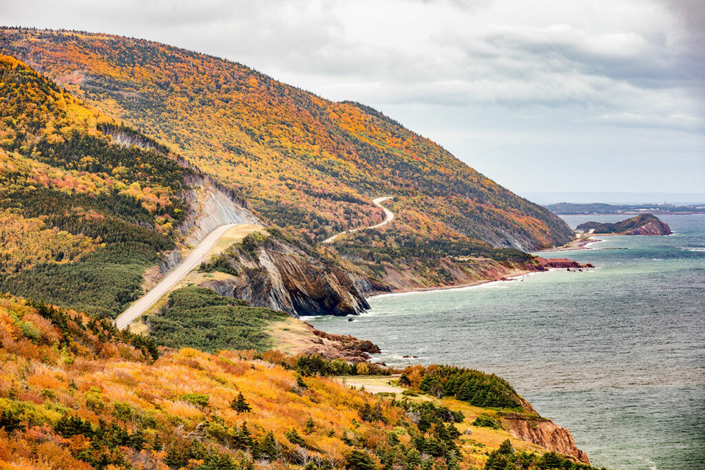 The famous Cabot trail winding through the hills of the Cape Breton Highland National Park is particularly spectacular during the colourful fall season.
